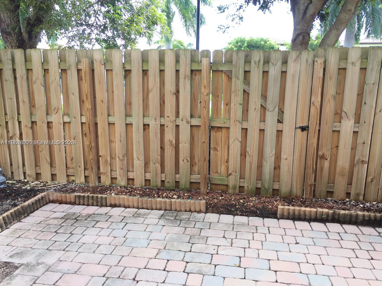 9041 Southwest 227th Street, Unit 5 Cutler Bay, FL 33190 - Photo 25 of 27 a view of wooden fence with a chair