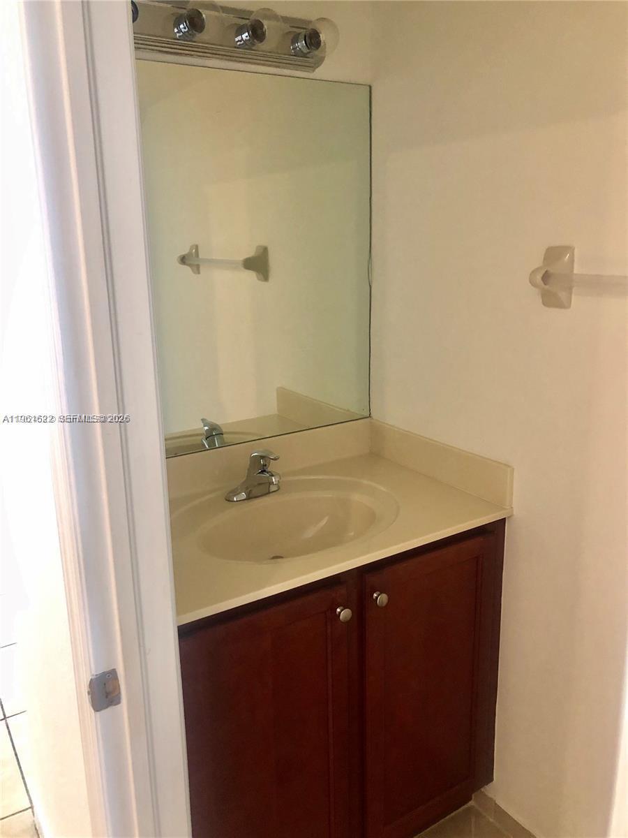 9041 Southwest 227th Street, Unit 5 Cutler Bay, FL 33190 - Photo 7 of 27 a bathroom with a sink and a mirror