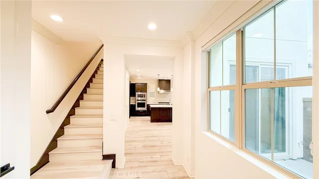 a view of a hallway with wooden floor and staircase
