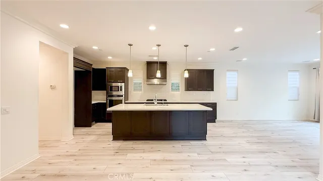 a view of kitchen with stainless steel appliances kitchen island sink refrigerator and microwave
