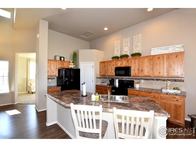 a kitchen with stainless steel appliances kitchen island granite countertop a sink and a stove