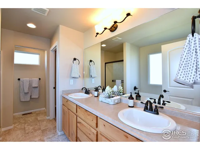 a en suite bathroom with a double vanity sink and mirror