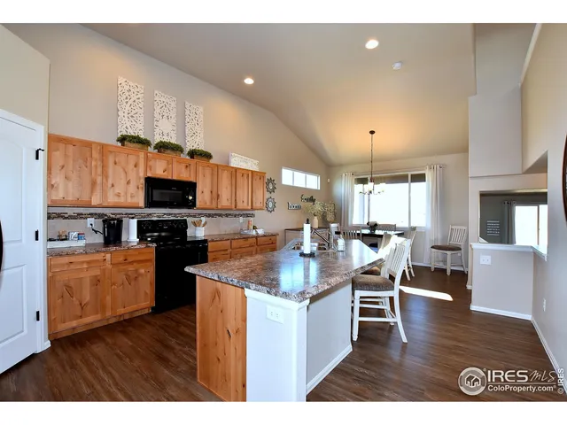 a kitchen with stainless steel appliances granite countertop wooden floors a stove and a microwave