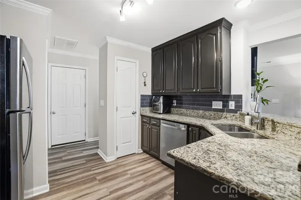 a kitchen with stainless steel appliances granite countertop a sink stove and refrigerator