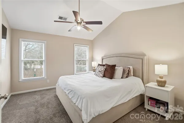 a bedroom with a bed a chandelier and a window
