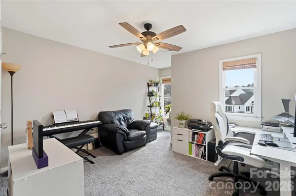 a work room with furniture and a ceiling fan
