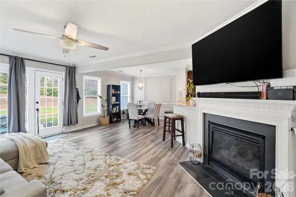 a living room with furniture a fireplace and a flat screen tv