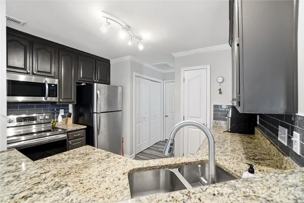 a kitchen with a refrigerator sink and wooden cabinets