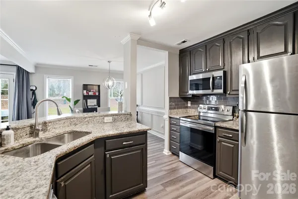 a kitchen with stainless steel appliances granite countertop a sink stove and refrigerator