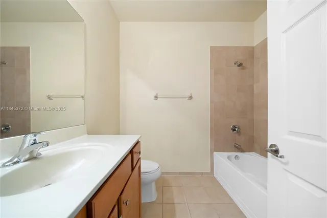 a bathroom with a granite countertop sink a toilet and bathtub