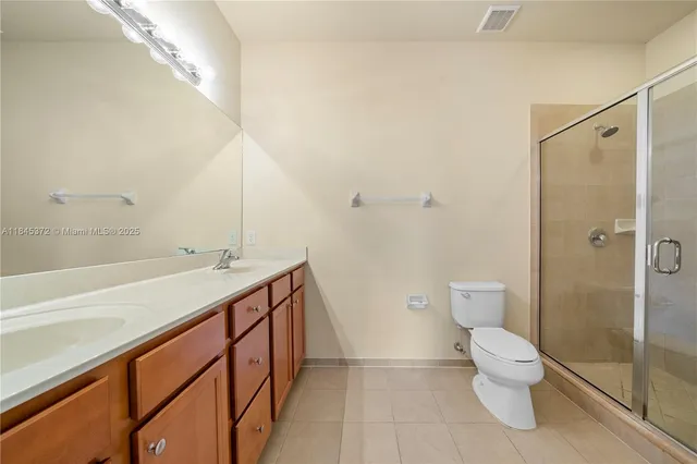 a bathroom with a double vanity sink toilet and shower