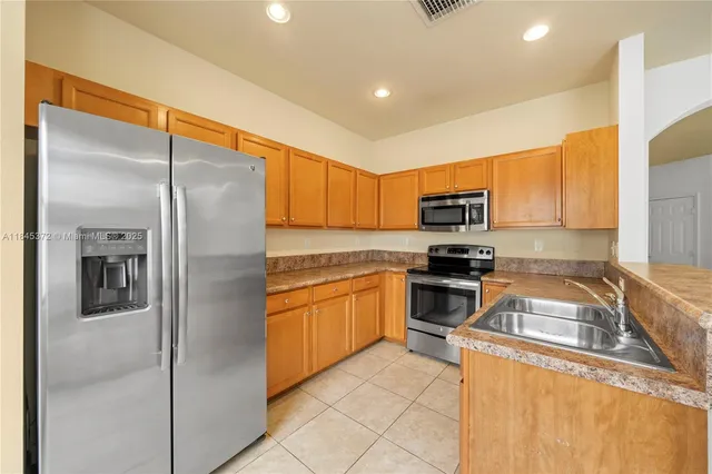 a kitchen with stainless steel appliances granite countertop a refrigerator and a sink