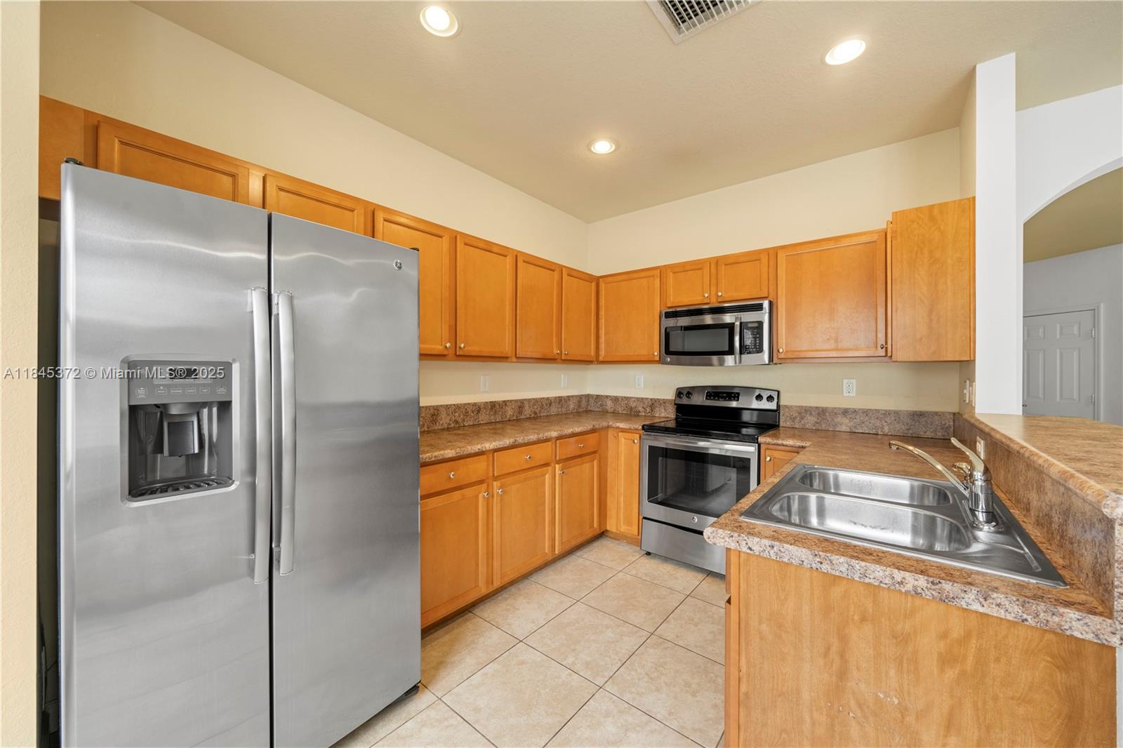 3366 West 90th Terrace, Unit 3366 Hialeah, FL 33018 - Photo 10 of 26 a kitchen with stainless steel appliances granite countertop a refrigerator and a sink