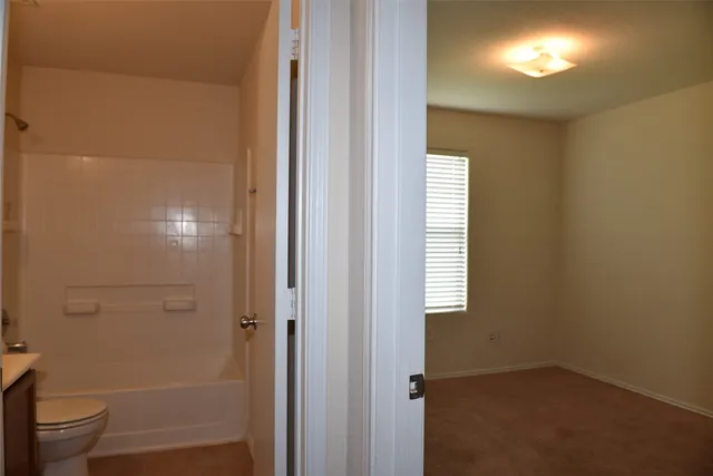 a bathroom with a toilet and a shower