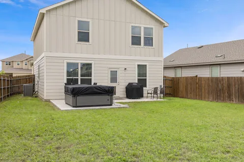 a view of a house with backyard and a tree