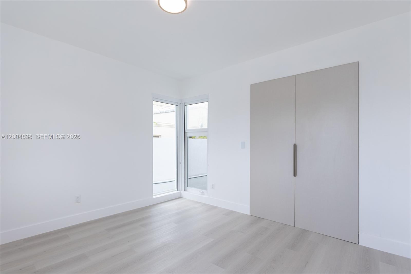 1690 Daytonia Road Miami Beach, FL 33141 - Photo 40 of 88 an empty room with wooden floor and mirror