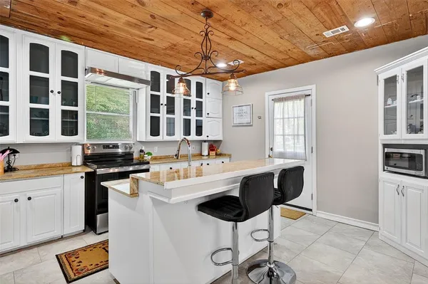 a large kitchen with stainless steel appliances granite countertop a stove and cabinets