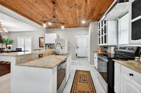 a kitchen with stainless steel appliances granite countertop a sink stove and cabinets