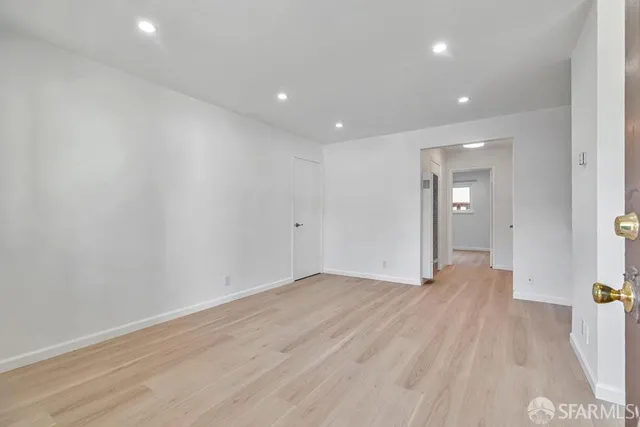 a view of an empty room with wooden floor