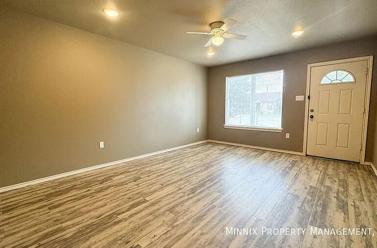 517 44th Street Lubbock, TX 79404 - Photo 2 of 10 an empty room with wooden floor and windows