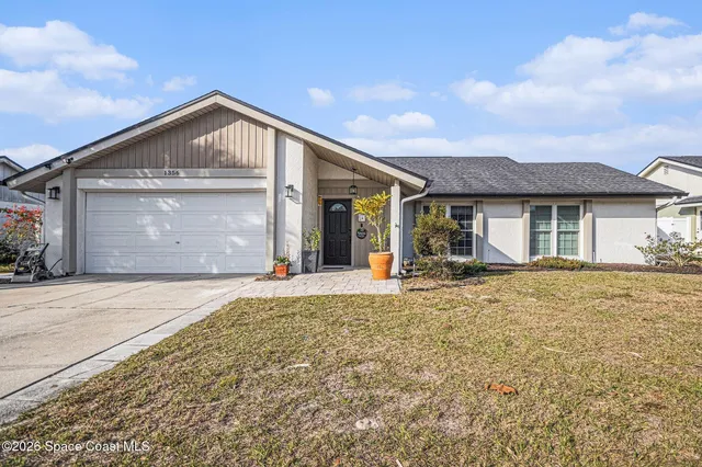 a front view of a house with a garden and yard