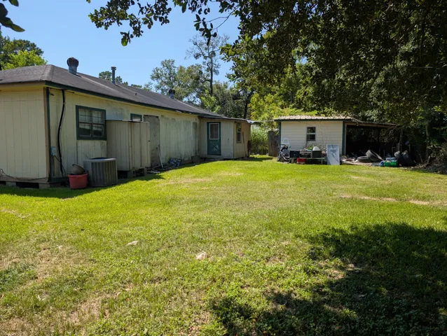 a view of a backyard with potted plants and a large tree