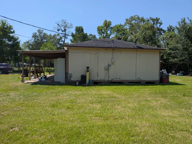 a view of a backyard with table and chairs under an umbrella