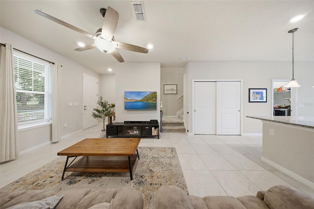 2117 Gopher Tortoise Terrace Oakland, FL 34787 - Photo 8 of 36 a living room with furniture a flat screen tv and kitchen view