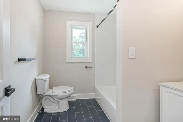 a white toilet sitting next to a bathroom sink and vanity