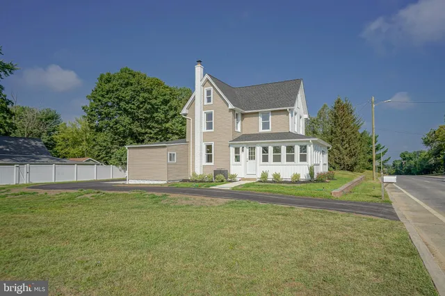 a view of a house with a big yard and large trees