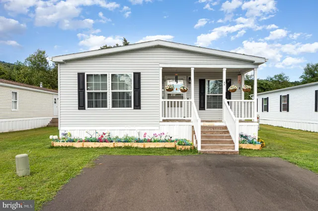 a front view of a house with a garden and yard