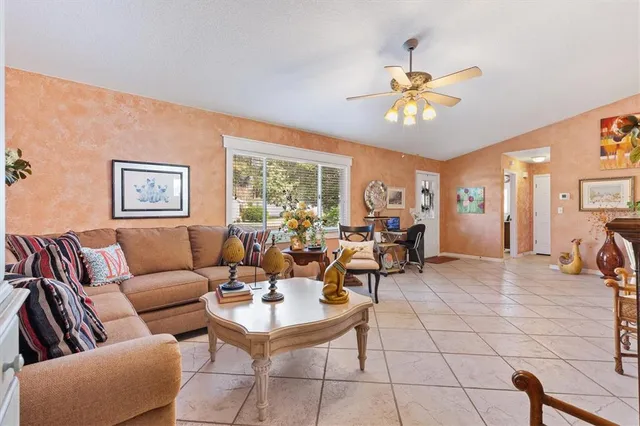 a living room with furniture a chandelier and a window
