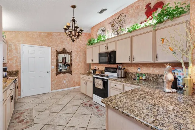 a kitchen with stainless steel appliances granite countertop a sink and a stove