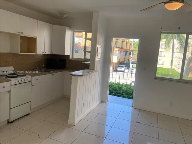 a kitchen with a sink a counter top space appliances and cabinets