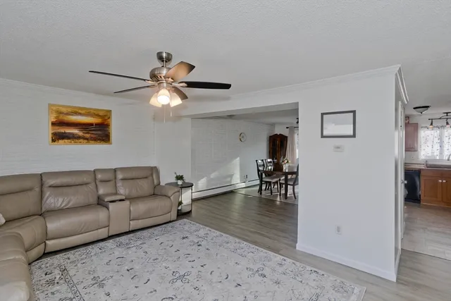 a living room with furniture and a dining table with wooden floor