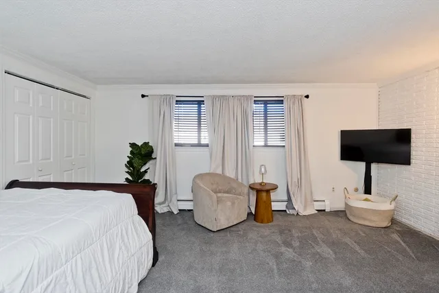 a spacious bedroom with a bed and a flat screen television