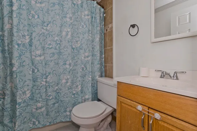 a bathroom with a granite countertop toilet and a sink