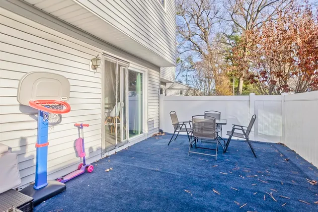 a view of a patio with table and chairs and wooden fence
