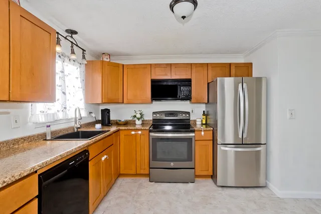 a kitchen with stainless steel appliances granite countertop a refrigerator sink stove microwave and cabinets