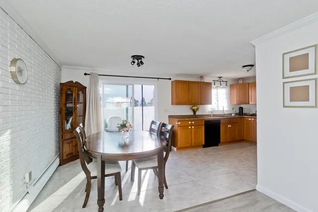 a kitchen with stainless steel appliances kitchen island granite countertop a table chairs sink and cabinets