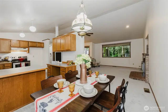 a view of a dining room and livingroom with furniture wooden floor a chandelier
