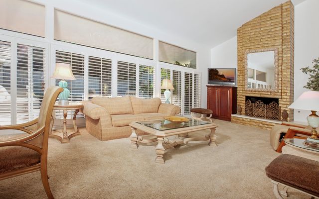 a living room with furniture a fireplace and large windows