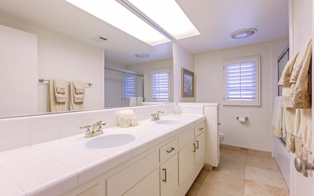 a spacious bathroom with double sink and a mirror