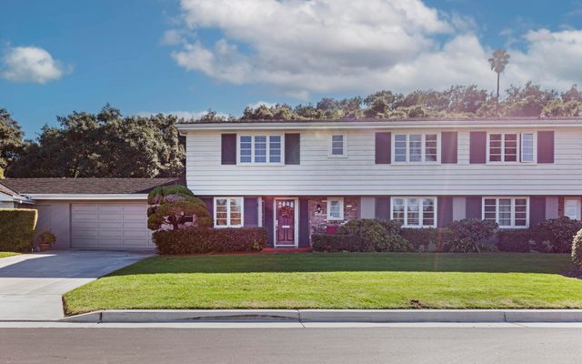 a front view of a house with a garden and yard