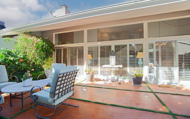 a view of a chairs and table in the back yard of the house