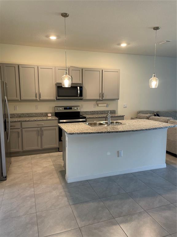 11427 Planetree Place Bradenton, FL 34211 - Photo 3 of 28 a kitchen with kitchen island granite countertop a stove a sink a counter top space and cabinets