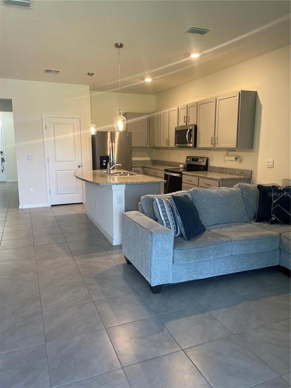 11427 Planetree Place Bradenton, FL 34211 - Photo 5 of 28 a living room with stainless steel appliances kitchen island granite countertop a sink and cabinets