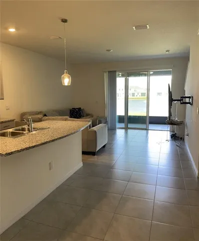 a kitchen with a sink a counter top space and a view of living room