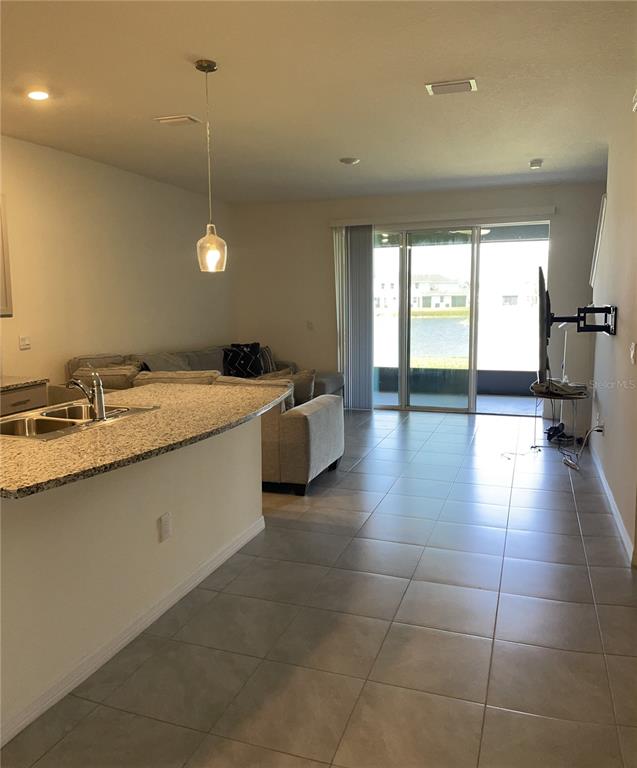 11427 Planetree Place Bradenton, FL 34211 - Photo 6 of 28 a kitchen with a sink a counter top space and a view of living room
