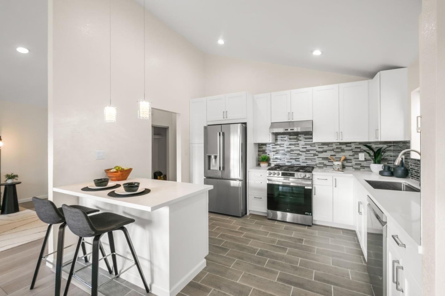 415 C Street Colma, CA 94014 - Photo 19 of 45 a kitchen with stainless steel appliances kitchen island granite countertop a stove a sink a refrigerator and a refrigerator